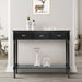 A black console table with three drawers, placed against a blue wall with a lamp and decorative items on top.